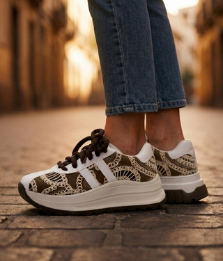 Zapatillas de plataforma blanca con bordado cafe sobre adoquines